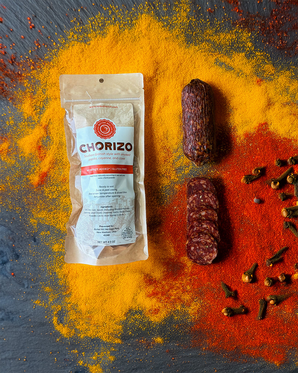 Chorizo package with spices and sausages on a dark surface