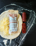 Dough with cheese and pepperoni packaging on a flour-dusted surface